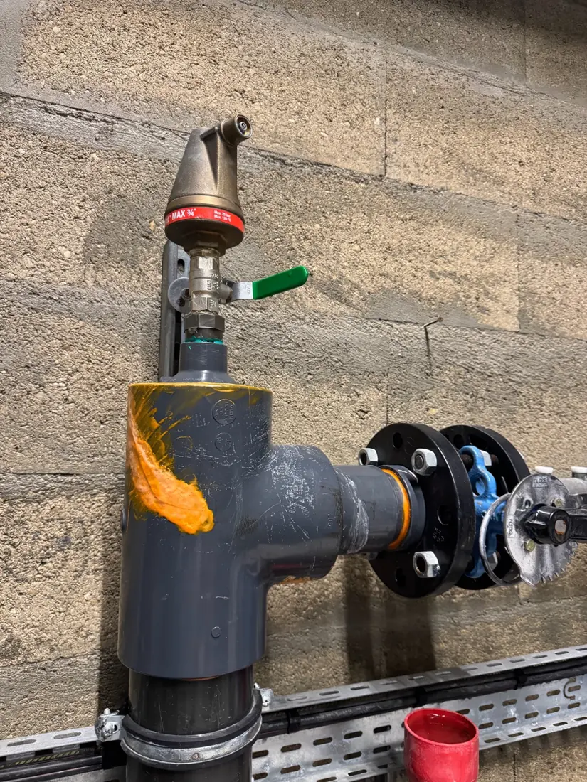 Assemblage de tuyauterie PVC grise avec raccordement à brides et organes de commande sur un site industriel